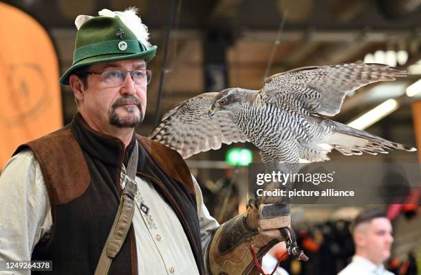 March 2023, Thuringia, Erfurt: Rainer Pfeffer from Luisenthal presents his goshawk at the opening of the "Reiten-Jagen-Fischen" and "Forst3" trade...