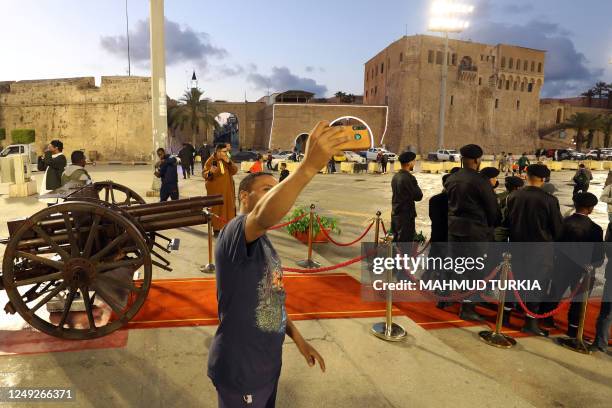 In this picture taken on March 23 a man takes a selfie as Tripoli municipality officials prepare to fire the Iftar cannon marking the time to break...