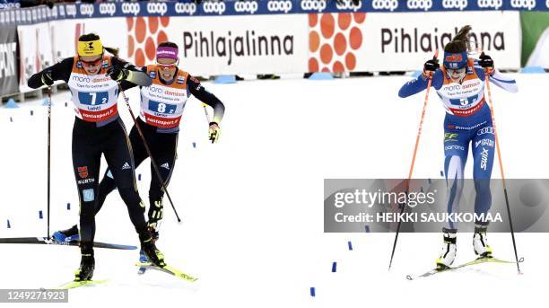 Coletta Rydzek of Germany, Sofie Krehl of Germany and Jasmin Kahara of Finland compete at the finish in the Cross-Country free style Women's Team...