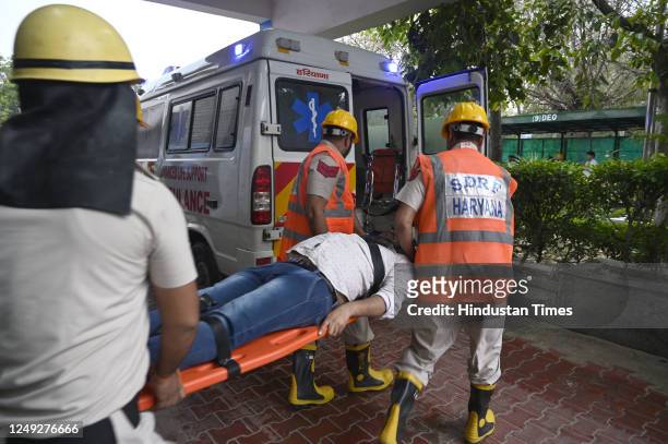 Team members of NDRF, Fire department , Haryana Police and civil defense during the rescue operation of earthquake mock drill in Mini Secretariat, on...