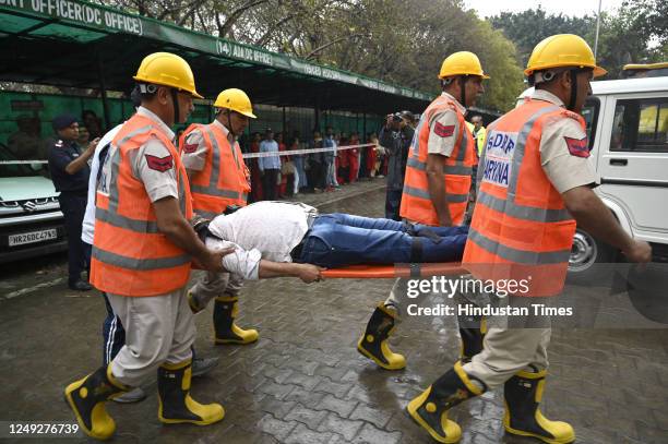 Team members of NDRF, Fire department , Haryana Police and civil defense during the rescue operation of earthquake mock drill in Mini Secretariat, on...