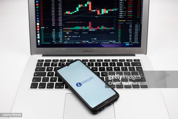 In this photo illustration a Litecoin logo seen displayed on a smartphone screen and an Exchange graph on a MacBook screen in Athens, Greece on March...