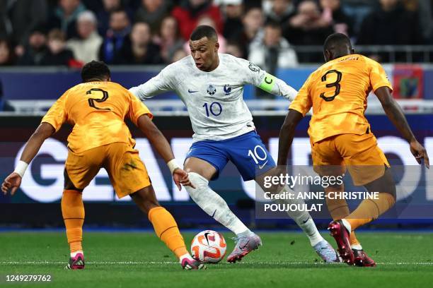 France's forward Kylian Mbappe fights for the ball with Netherlands' midfielder Jurrien Timber and Netherlands' defender Lutsharel Geertruida during...