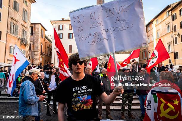 Demonstrator holds a sign that reads: " No to sending arms to the Ukrainian puppet regime" during a demonstration organised by the Italian Communists...