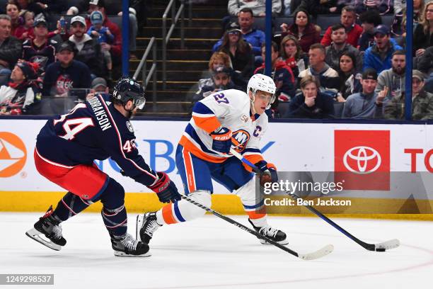 Anders Lee of the New York Islanders skates with the puck as Erik Gudbranson of the Columbus Blue Jackets defends during the second period of a game...