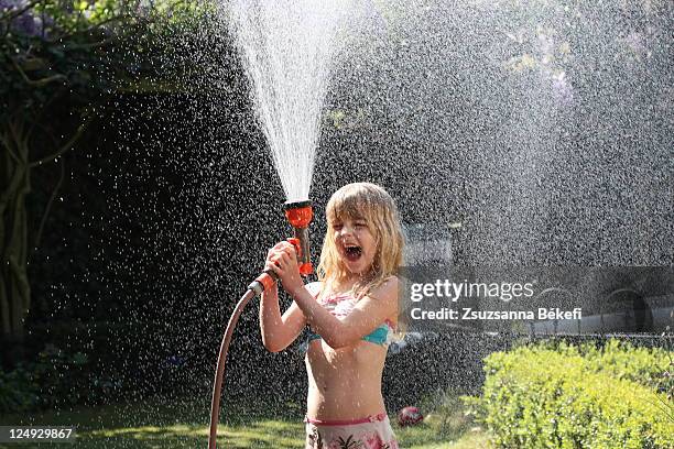 little girl enjoying with garden sprinkler - spraying stock pictures, royalty-free photos & images