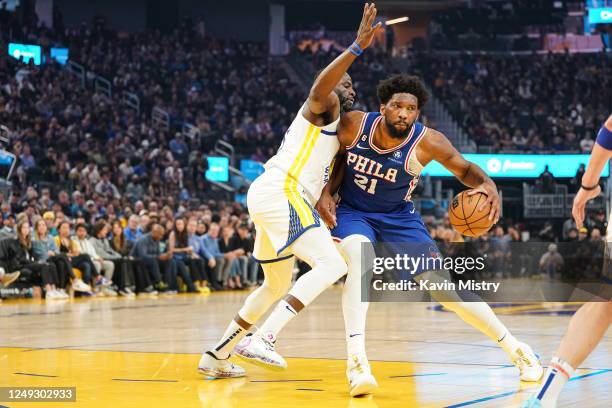 Joel Embiid of the Philadelphia 76ers dribbles the ball in the first quarter against Draymond Green of the Golden State Warriors at Chase Center on...