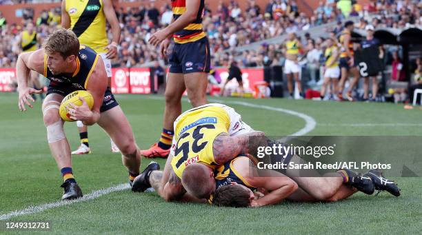 Patrick Parnell of the Crows is tackled by Nathan Broad of the Tigers during the 2023 AFL Round 02 match between the Adelaide Crows and the Richmond...