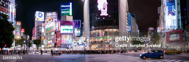 panoramic scene of the shibuya intersection and the surrounding buildings at night - distrito de shibuya fotografías e imágenes de stock