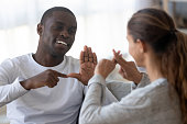 Smiling multiracial friends talk using sign language
