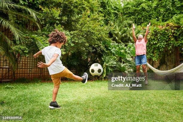 spaß beim ballspielen mit oma - backyard football stock-fotos und bilder