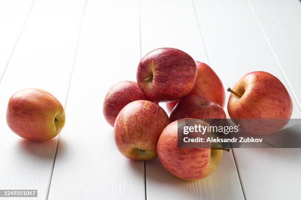 red ripe apples on a white wooden background. vegetarian, vegan, raw food. - apple white background stock-fotos und bilder