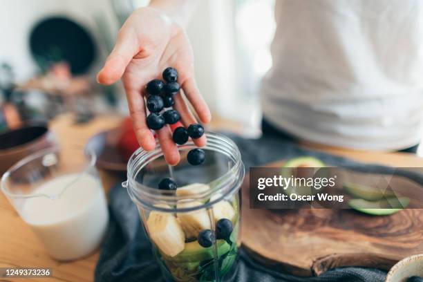 making vegan smoothie for a healthy diet - banana woman photos et images de collection