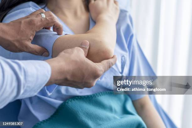 orthopedist examining patient in hospital - man touching shoulder stock-fotos und bilder