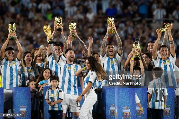 Argentina's Lionel Messi and teammates celebrate with their families and World Cup trophies after an international friendly soccer match against...