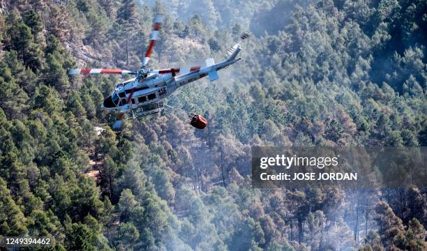 Helicopter overflies a forest area near the village of Los Peiros, on March 25 to fight a wildfire that began on March 23, 2023 near Villanueva de...