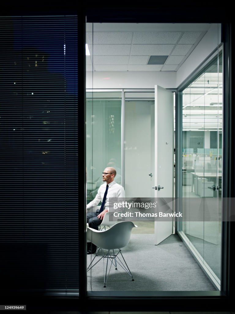 Businessman in empty office at night