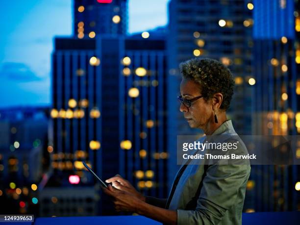 businesswoman working on digital tablet at night - selective focus foto e immagini stock
