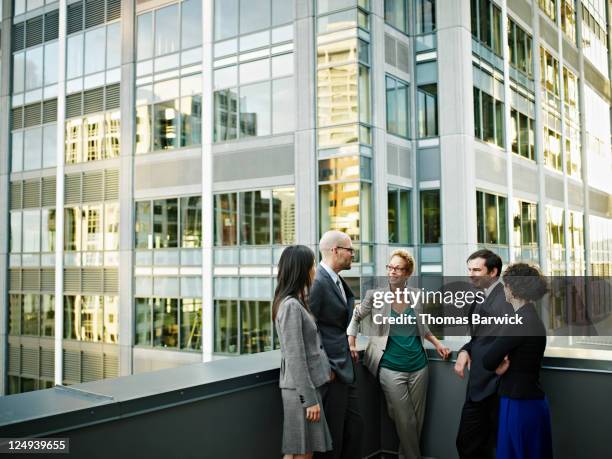 group of coworkers standing in discussion outside - business outdoor stockfoto's en -beelden