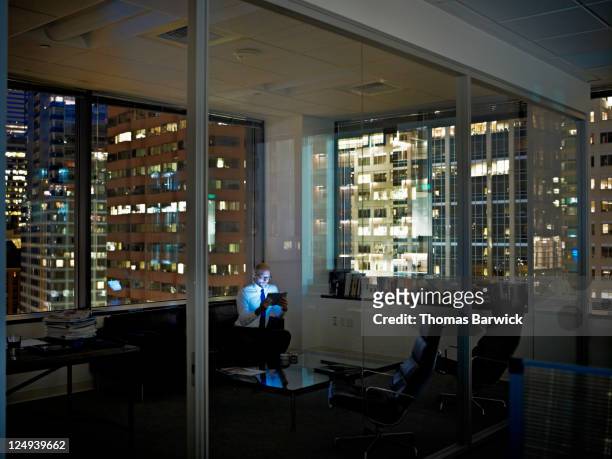 Businessman with digital tablet in office at night