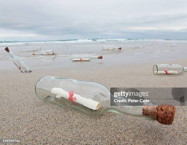 messages in bottles washed up on beach - flaschenpost stock-fotos und bilder