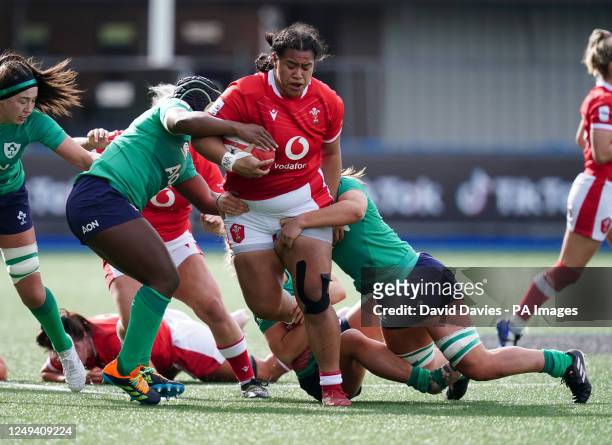 Wales' Sisilia Tuipulotu is tackled by Ireland's Linda Djougang and Brittany Hogan during the TikTok Women's Six Nations match at Cardiff Arms Park,...