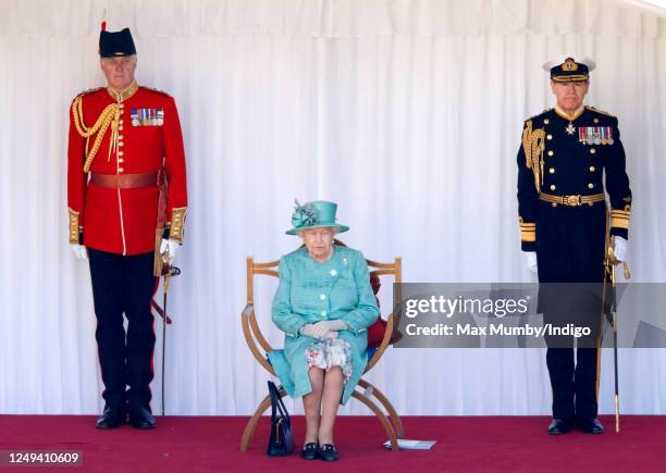 Queen Elizabeth II, accompanied by Lieutenant Colonel Michael Vernon and Vice Admiral Tony Johnstone-Burt , attends a military ceremony in the...