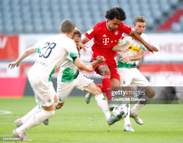 Joshua Zirkzee of Muenchen is challenged by Matthias Ginter, Tony Jantschke and Christoph Kramer of Moenchengladbach during the Bundesliga match...