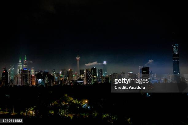 View of the KLCC Twin Towers and KL Tower after the main lights were turned off in conjunction with the "Earth Hour" 2023 event in Kuala Lumpur,...