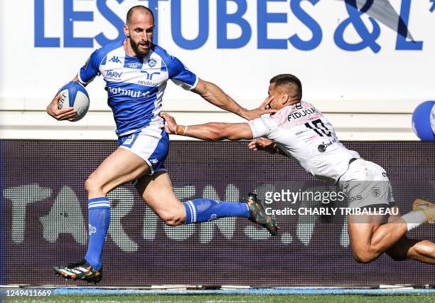 Castres' French full-back Julien Dumora runs to score a try and avoids a tackle by Toulouse's Samoan winger Tim Nanai-Williams during the French...