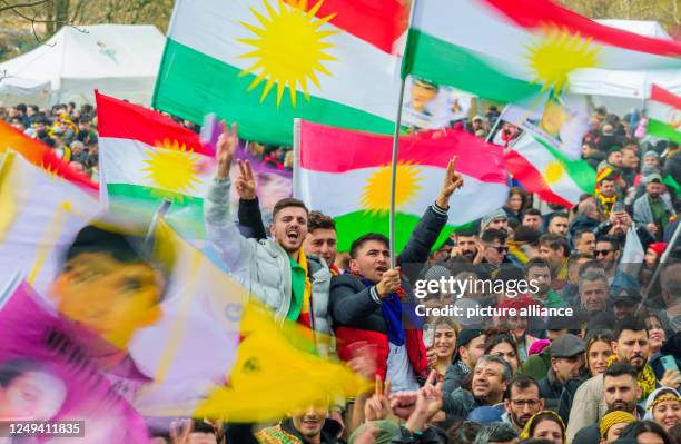 Dpatop - 25 March 2023, Hesse, Frankfurt/Main: People take part in the central celebration of the Kurdish New Year "Newroz", waving flags of...
