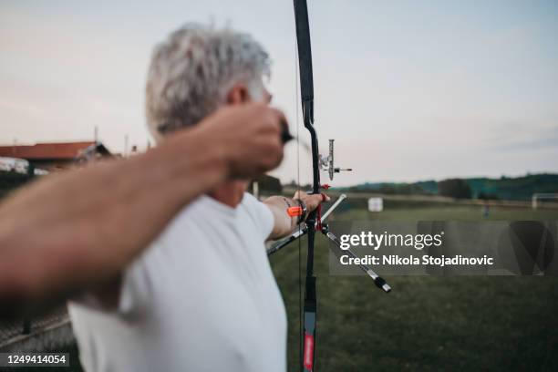 archer en entrenamiento - bow and arrow fotografías e imágenes de stock