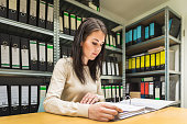 Female Finance Accountant Controlling Document Files in Finance File Archive