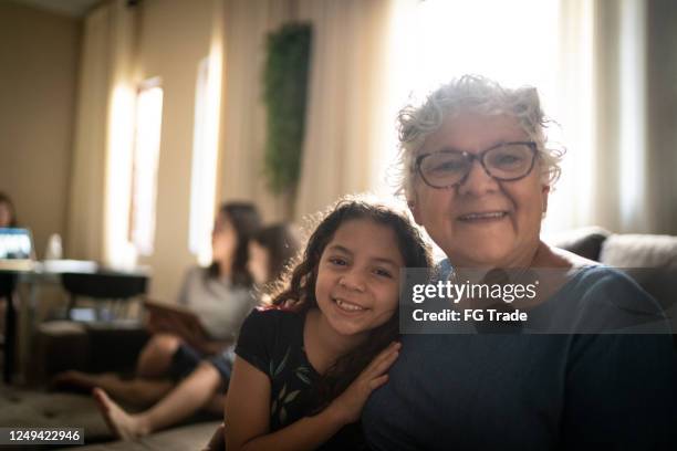 porträt von großmutter und enkelin zu hause - humility stock-fotos und bilder