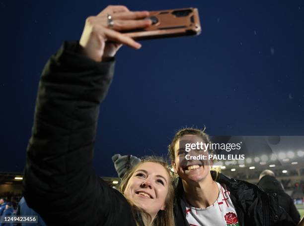 England's number 8 Sarah Hunter has a selfie photograph taken with a fan after the Six Nations international women's rugby union match between...