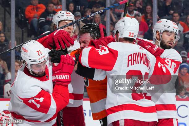 Brendan Lemieux of the Philadelphia Flyers gets into an altercation with Dylan Larkin, Moritz Seider, Lucas Raymond, and Jake Walman of the Detroit...