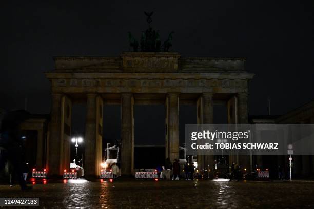The lights of the Brandenburg Gate in Berlin are switched off during "Earth Hour" on March 25, 2023.