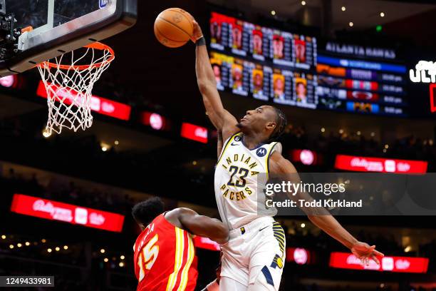 Aaron Nesmith of the Indiana Pacers dunks over Clint Capela of the Atlanta Hawks during the first half at State Farm Arena on March 25, 2023 in...