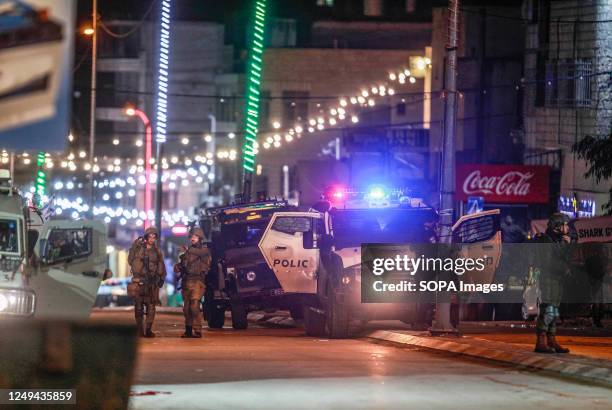 Israeli soldiers and intelligence forces inspect the site of a shooting attack on two Israeli soldiers in the town of Hawara, south of Nablus, in the...