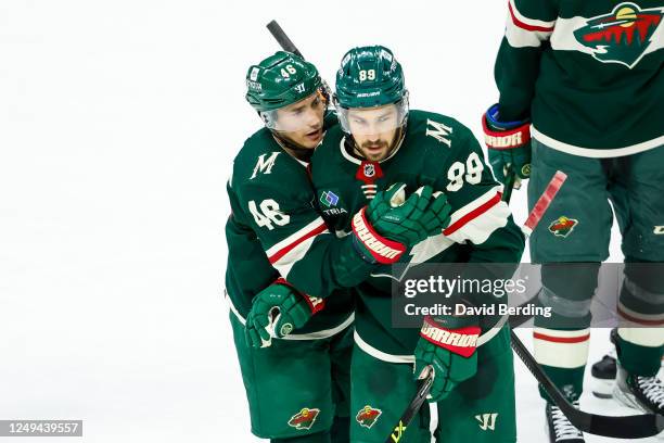 Frederick Gaudreau of the Minnesota Wild celebrates his empty net goal against the Chicago Blackhawks with teammate Jared Spurgeon in the third...