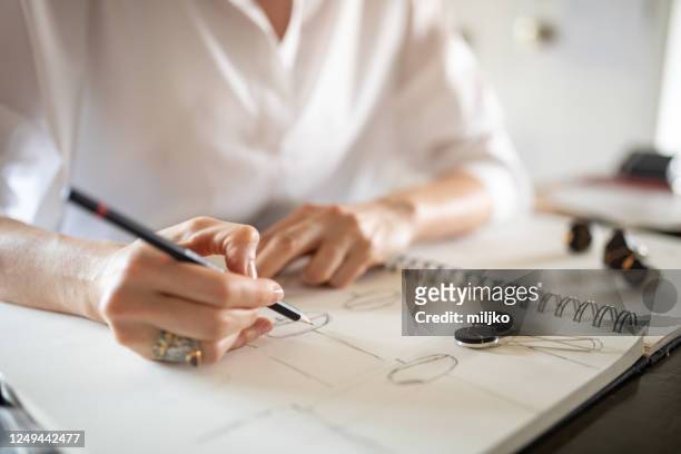 woman designing jewelry in her atelier - jewelry stock pictures, royalty-free photos & images