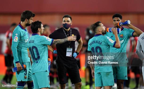 Lionel Messi of FC Barcelona talks to Eder Sarabia, assistant coach of FC Barcelona during the La Liga match between RCD Mallorca and FC Barcelona at...