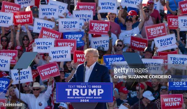 Supporters hold "Witch Hunt" signs as former US President Donald Trump speaks during a 2024 election campaign rally in Waco, Texas, March 25, 2023. -...