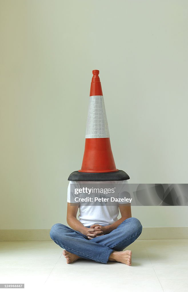 Teenager with traffic cone on his head