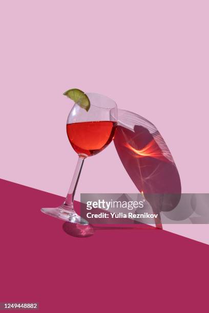 wine glass on the red-pink background - red wine stockfoto's en -beelden