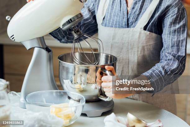 unrecognizable woman using a stand mixer in the kitchen - stand mixer stock pictures, royalty-free photos & images