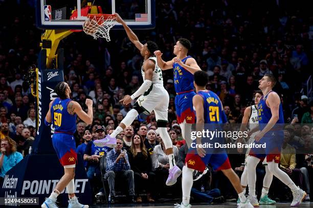 Giannis Antetokounmpo of the Milwaukee Bucks scores on a first half slam dunk against the Denver Nuggets at Ball Arena on March 25, 2023 in Denver,...