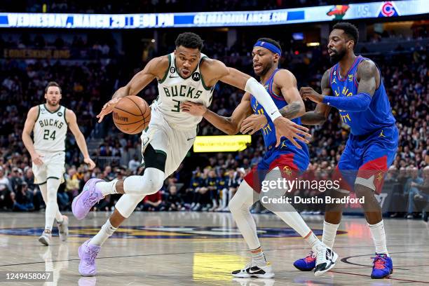 Giannis Antetokounmpo of the Milwaukee Bucks dribbles past Bruce Brown and Jeff Green of the Denver Nuggets in the second half of a game at Ball...