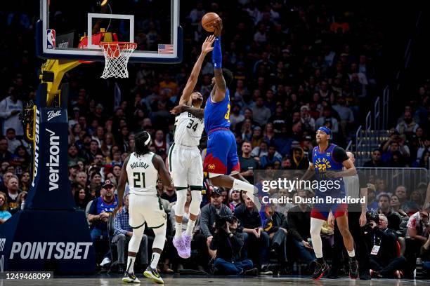 Jeff Green of the Denver Nuggets jumps to slam the ball over a block attempot by Giannis Antetokounmpo of the Milwaukee Bucks in the second half of a...