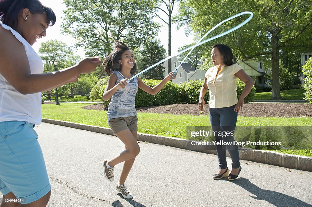 Jump Rope Mama Mother And Kids Jumping Rope On Suburban Street High-Res Stock Photo ...